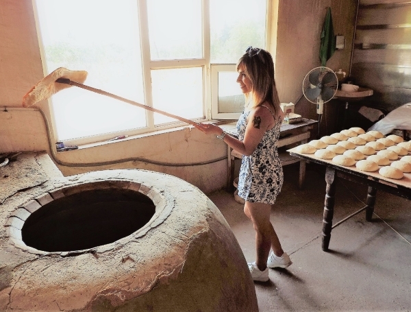 A local baker lets Malka take the bread out of the oven