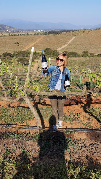 Malka in the vineyard with wine from Casas del Bosque